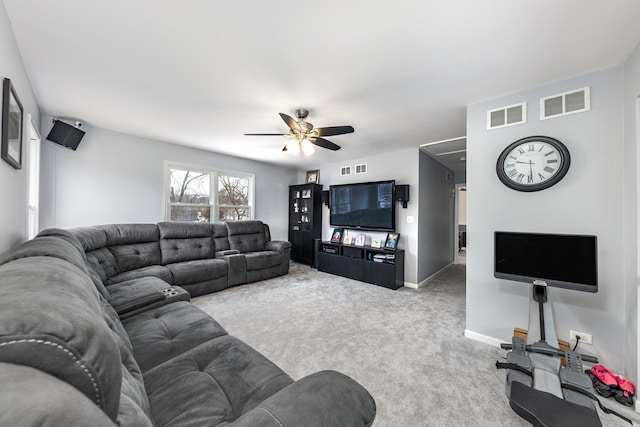living area featuring attic access, visible vents, carpet flooring, and ceiling fan