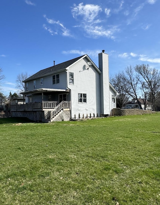rear view of property with a chimney, stairway, and a lawn