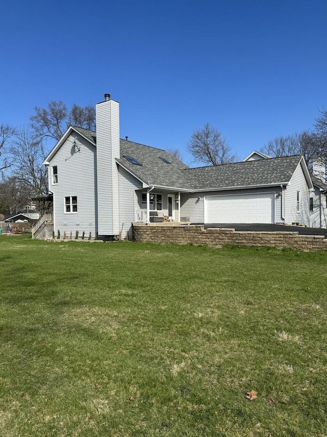 exterior space featuring a chimney, an attached garage, a shingled roof, and a front lawn