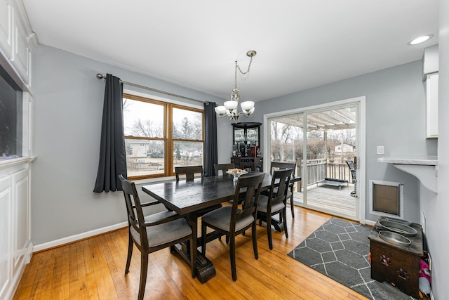 dining room featuring light wood finished floors, baseboards, recessed lighting, and a notable chandelier