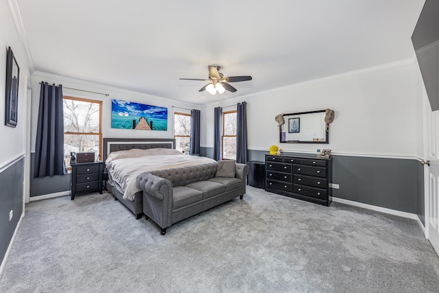 carpeted bedroom featuring multiple windows, a ceiling fan, baseboards, and ornamental molding
