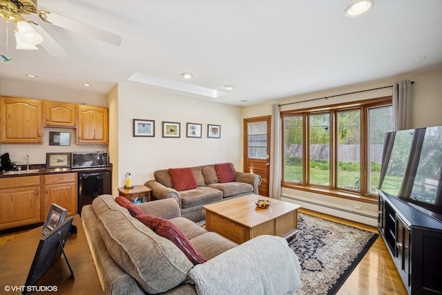 1704 Executive Ln, Glenview, IL 60026 - living room with a baseboard heating unit, a skylight, light wood-style floors, recessed lighting, and ceiling fan