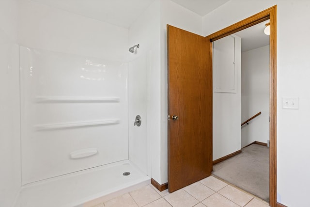 bathroom featuring baseboards, tile patterned flooring, and a stall shower