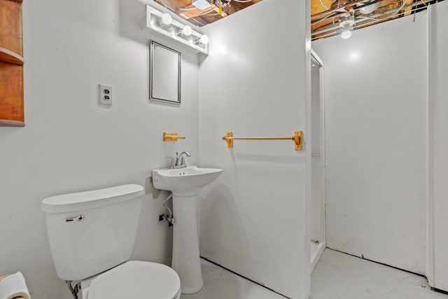 bathroom with concrete flooring, toilet, and a shower