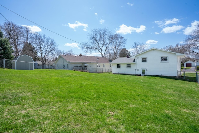 view of yard with a storage shed, a fenced backyard, and an outdoor structure
