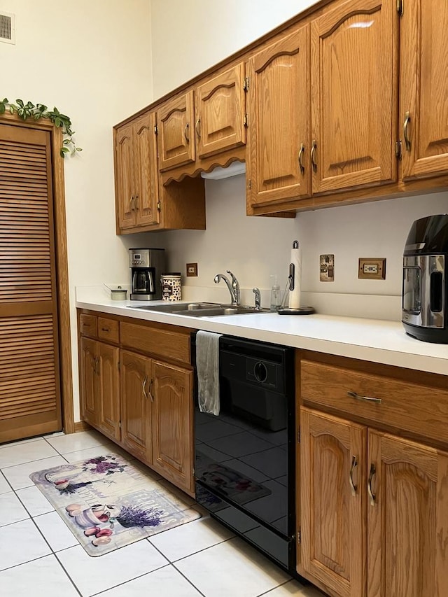 kitchen featuring a sink, light tile patterned floors, light countertops, and dishwasher