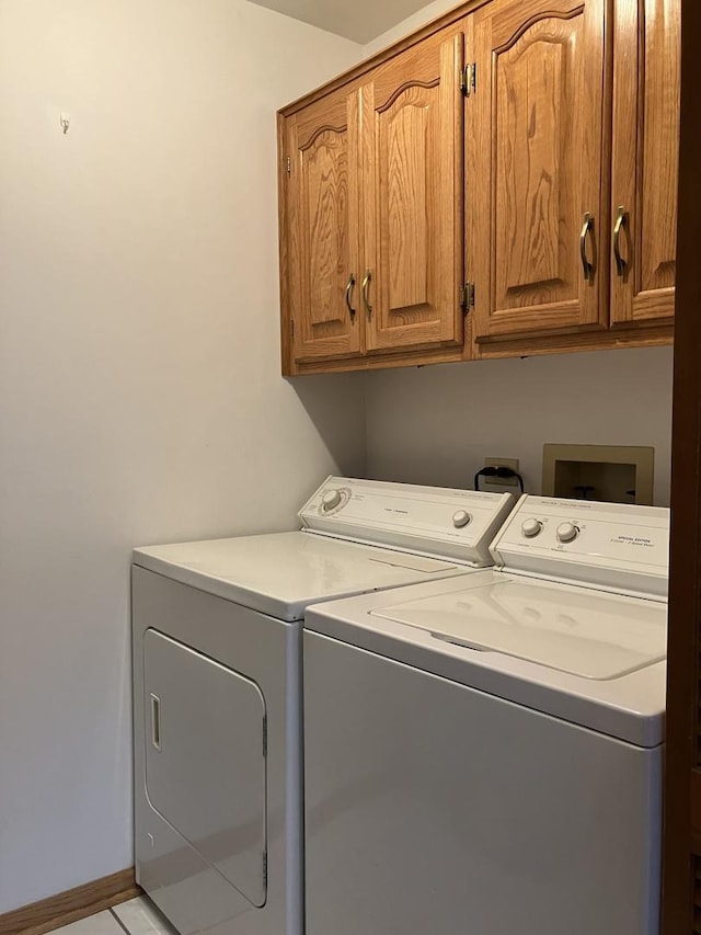 laundry room with separate washer and dryer and cabinet space