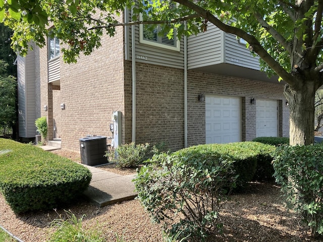 view of side of property with brick siding and an attached garage