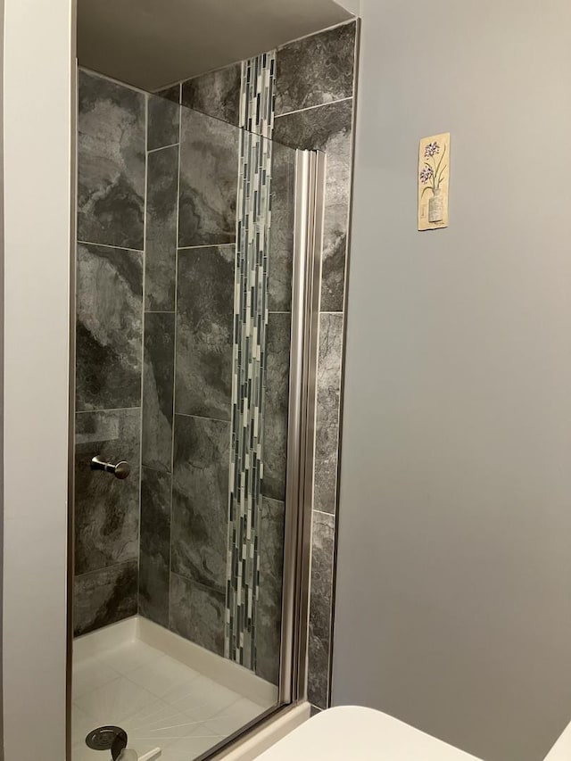 full bath featuring toilet and a stall shower