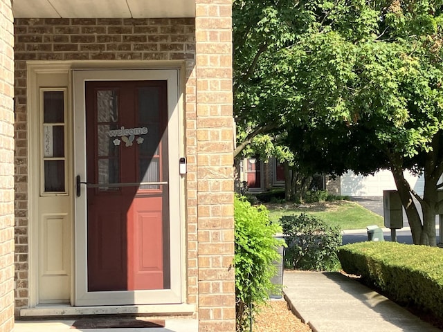 doorway to property with brick siding