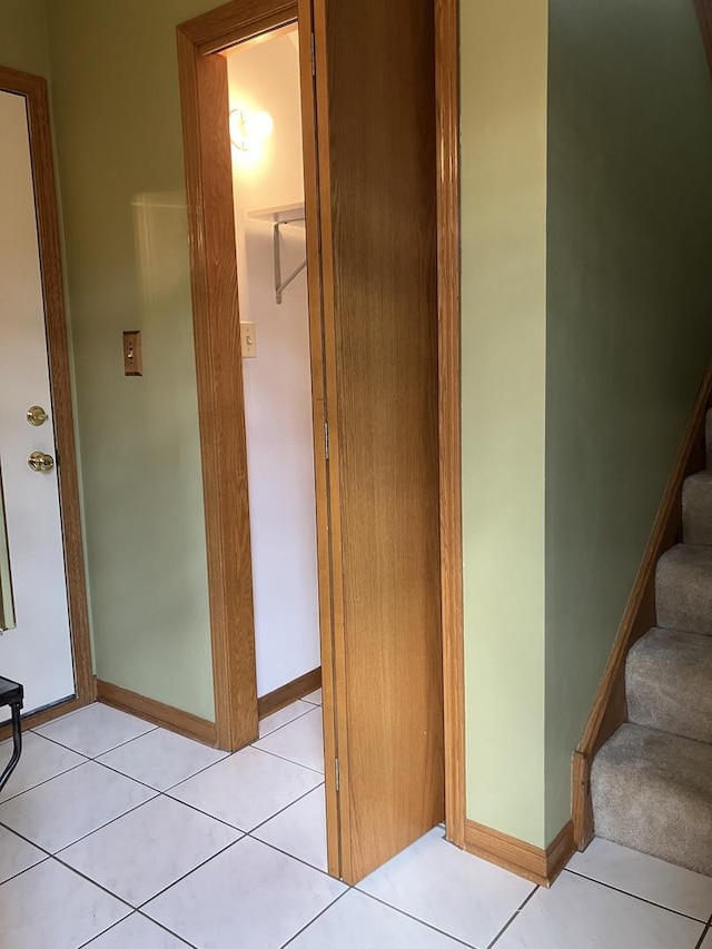 stairway with tile patterned floors and baseboards