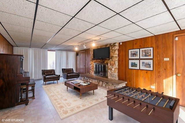 living room featuring wooden walls and a fireplace