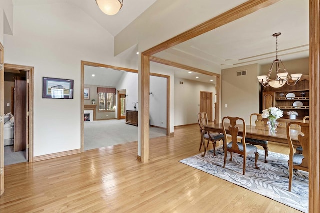 10440 Deer Chase Ave, Orland Park, IL 60467 - dining room featuring visible vents, baseboards, a notable chandelier, light wood-style floors, and a lit fireplace