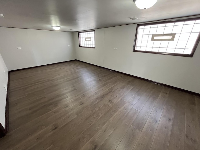 unfurnished room with baseboards, wood finished floors, and visible vents
