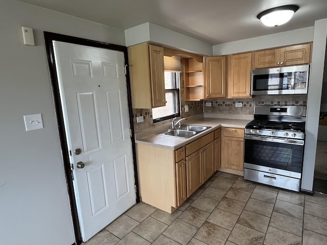 kitchen featuring light tile patterned flooring, a sink, light countertops, stainless steel appliances, and backsplash