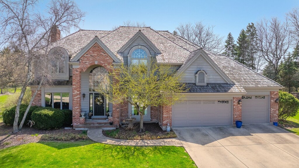 2987 Norwalk Ct, Aurora, IL 60502 - view of front of home featuring driveway, brick siding, a front yard, and a garage