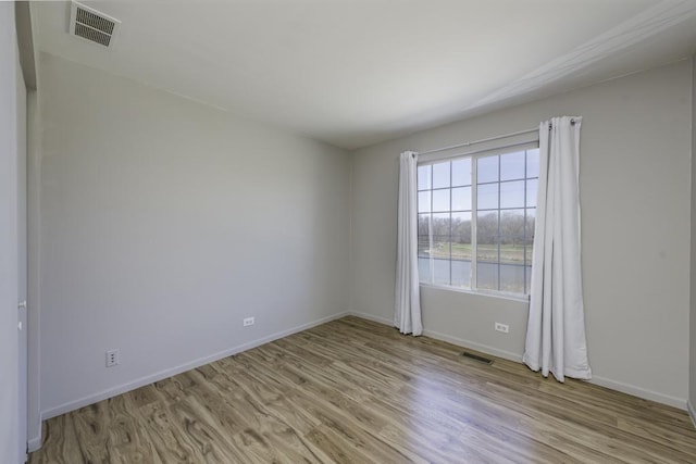 spare room with visible vents, baseboards, and light wood-style floors