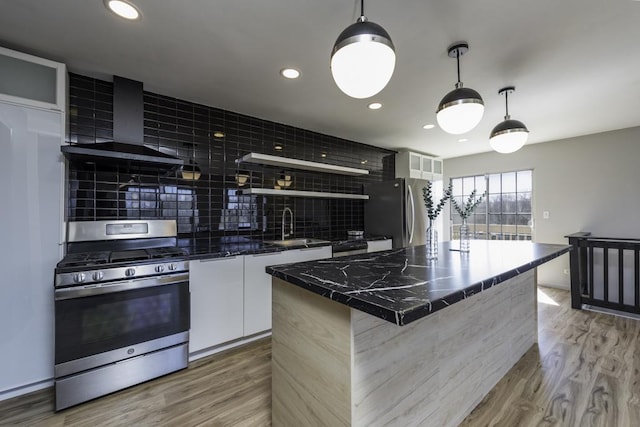 kitchen featuring open shelves, wall chimney exhaust hood, modern cabinets, a sink, and appliances with stainless steel finishes