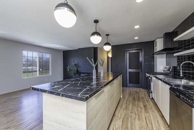 kitchen with refrigerator, light wood-style flooring, stainless steel gas range oven, dishwasher, and a sink