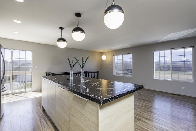kitchen featuring light wood-style flooring, dark countertops, a healthy amount of sunlight, and modern cabinets