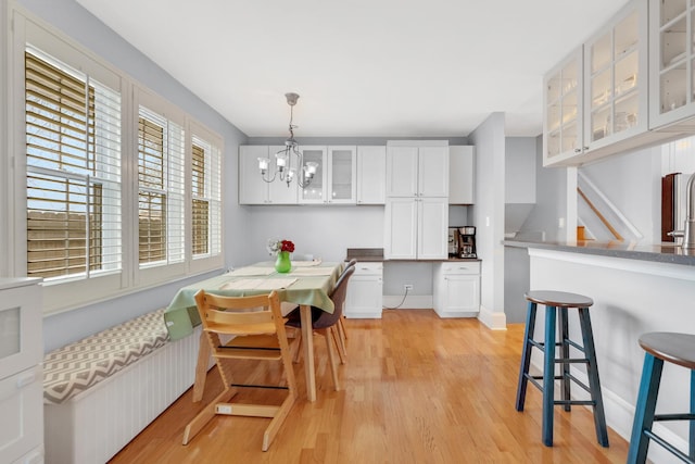 dining area with an inviting chandelier, light wood-style floors, and a healthy amount of sunlight