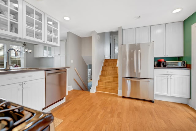 kitchen with white cabinetry, stainless steel appliances, and a sink