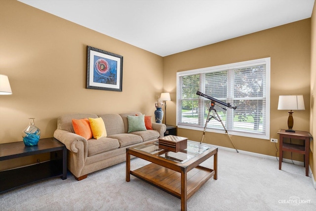 living area featuring light carpet and baseboards