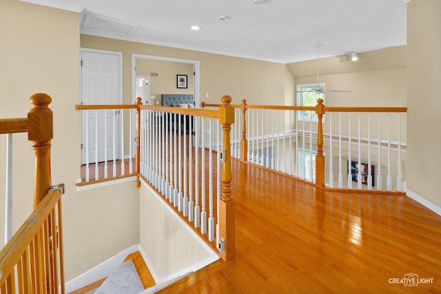 hall featuring an upstairs landing, wood finished floors, baseboards, ornamental molding, and recessed lighting