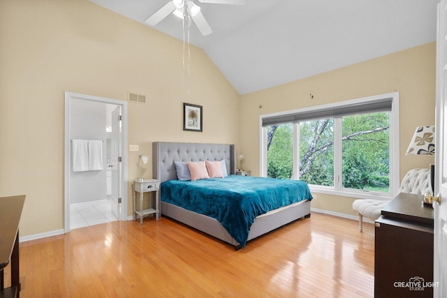 bedroom with wood-type flooring, baseboards, high vaulted ceiling, and connected bathroom