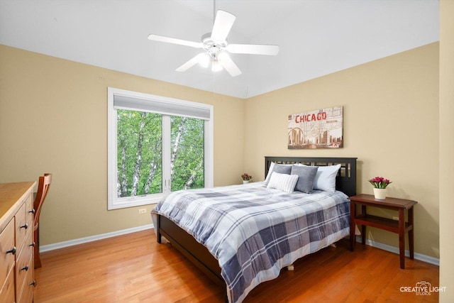 bedroom featuring light wood finished floors, baseboards, ceiling fan, and lofted ceiling