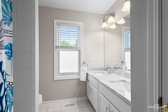 bathroom featuring plenty of natural light, baseboards, tile patterned floors, and toilet