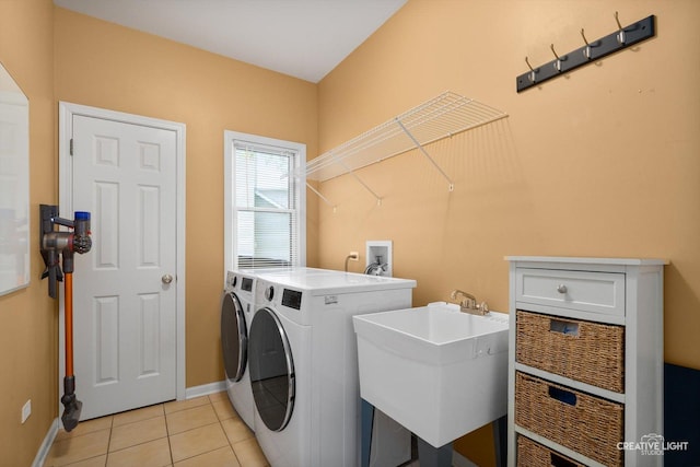 laundry area featuring washer and clothes dryer, baseboards, and light tile patterned floors