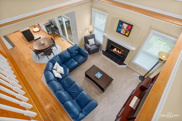 living area featuring a tiled fireplace, wood finished floors, and baseboards
