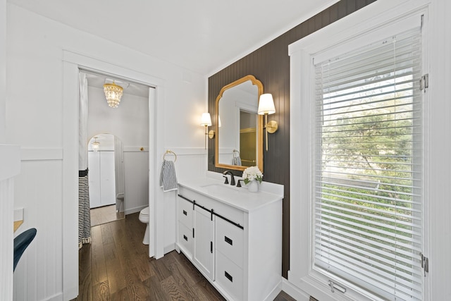 209 Oak Cv, Lake Holiday, IL 60552 - bathroom featuring wood finished floors, vanity, a wainscoted wall, toilet, and a decorative wall