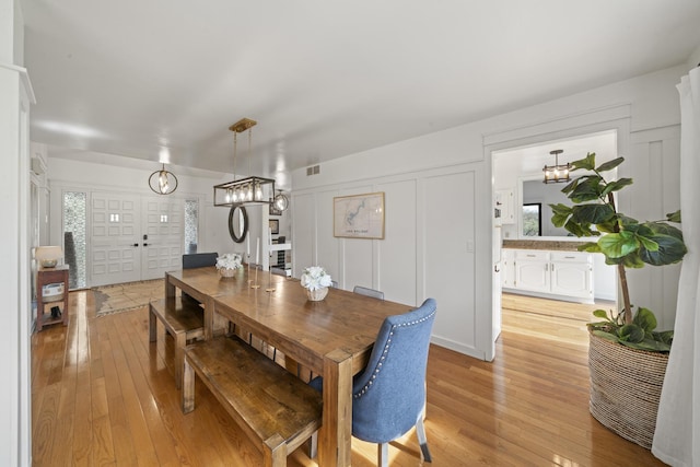 209 Oak Cv, Lake Holiday, IL 60552 - dining area with light wood-style floors, visible vents, a notable chandelier, and a healthy amount of sunlight