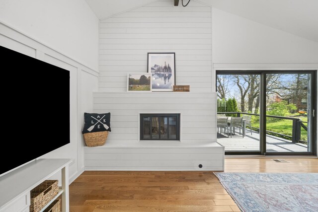 209 Oak Cv, Lake Holiday, IL 60552 - unfurnished living room with high vaulted ceiling, a fireplace, wood finished floors, and visible vents