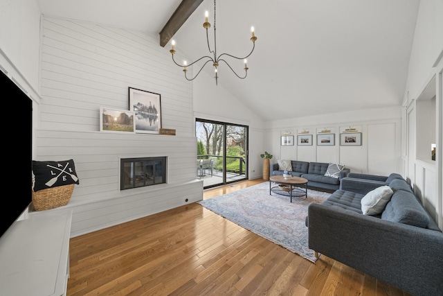 209 Oak Cv, Lake Holiday, IL 60552 - living area with a fireplace, wood finished floors, beam ceiling, high vaulted ceiling, and a notable chandelier