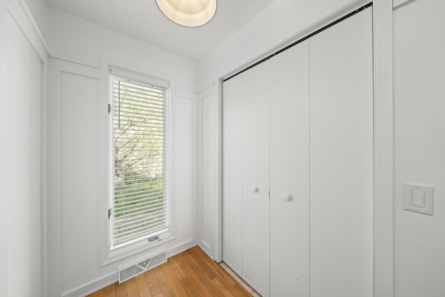 209 Oak Cv, Lake Holiday, IL 60552 - unfurnished bedroom with visible vents, multiple windows, light wood finished floors, and a closet