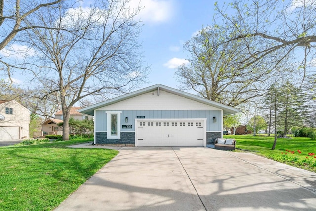 209 Oak Cv, Lake Holiday, IL 60552 - view of front of house featuring concrete driveway, an attached garage, stone siding, and a front lawn