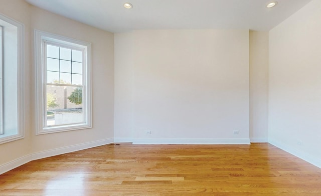 unfurnished room featuring light wood finished floors, plenty of natural light, and recessed lighting