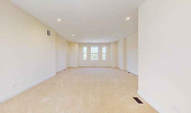 unfurnished room with recessed lighting, visible vents, light colored carpet, and baseboards