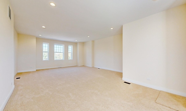 spare room with light colored carpet, baseboards, visible vents, and recessed lighting