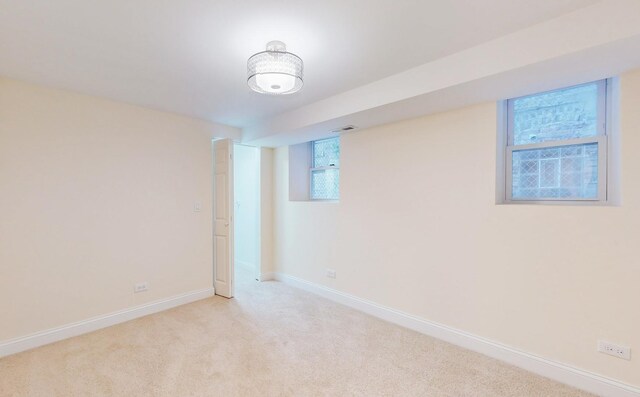 below grade area with visible vents, baseboards, and light colored carpet