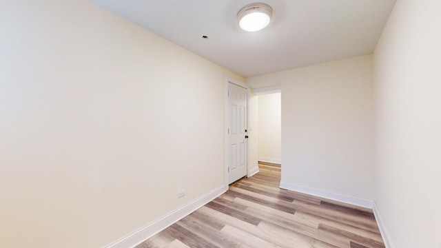 spare room with light wood-type flooring and baseboards