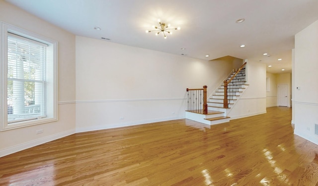 unfurnished room featuring baseboards, recessed lighting, light wood-style floors, and stairs