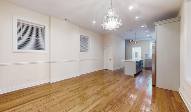 spare room with baseboards, a chandelier, recessed lighting, visible vents, and light wood finished floors