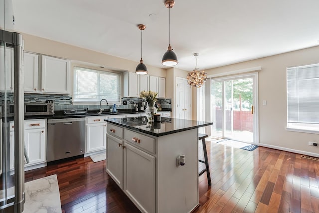 2704 Flagstone Cir, Naperville, IL 60564 - kitchen featuring dishwasher, a kitchen breakfast bar, decorative backsplash, and dark countertops