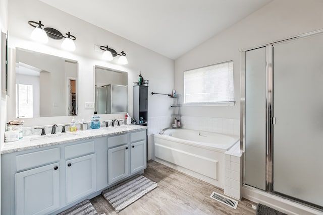 2704 Flagstone Cir, Naperville, IL 60564 - bathroom featuring vaulted ceiling, a stall shower, visible vents, a sink, and wood finished floors