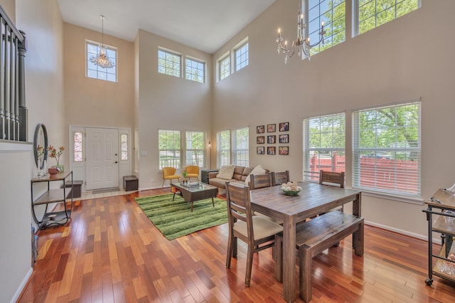 2704 Flagstone Cir, Naperville, IL 60564 - dining area featuring wood-type flooring, a high ceiling, a notable chandelier, and baseboards