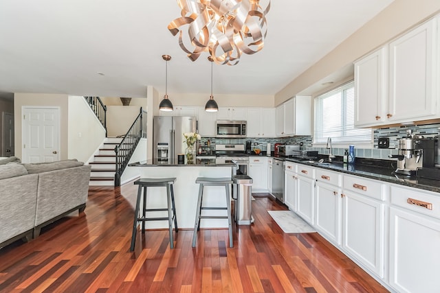 2704 Flagstone Cir, Naperville, IL 60564 - kitchen featuring backsplash, white cabinets, appliances with stainless steel finishes, and a notable chandelier